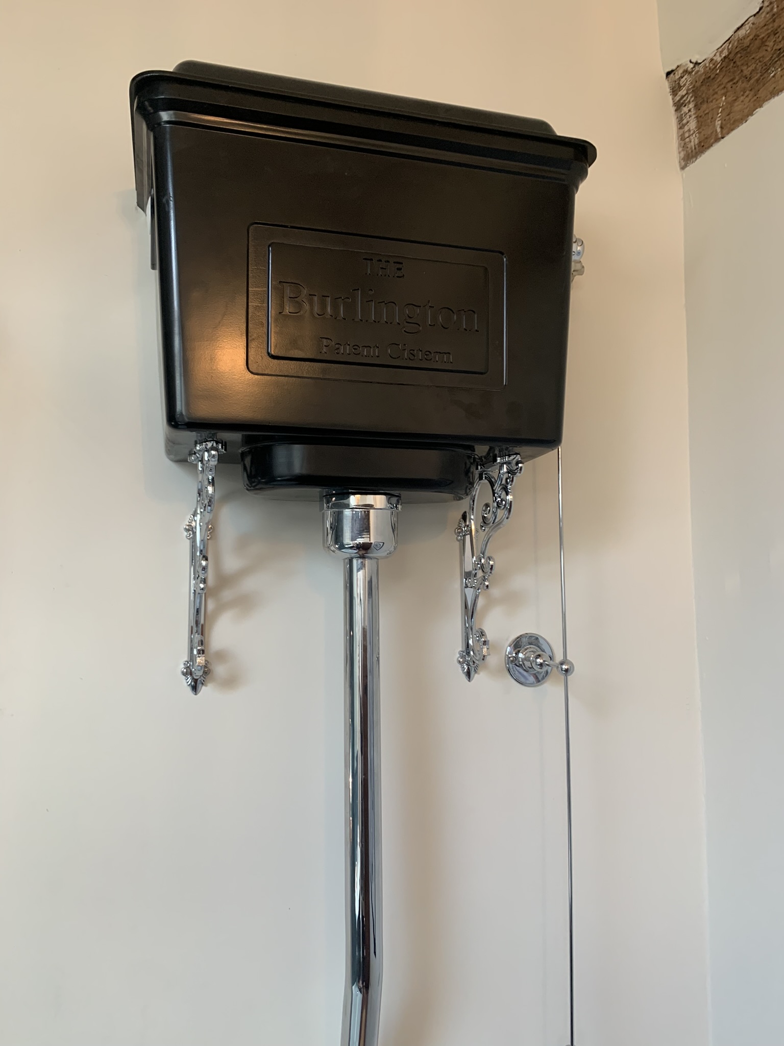 Black high-level cistern with chrome brackets and flush pipe